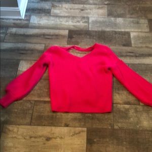 Bright pink sweater with open back.